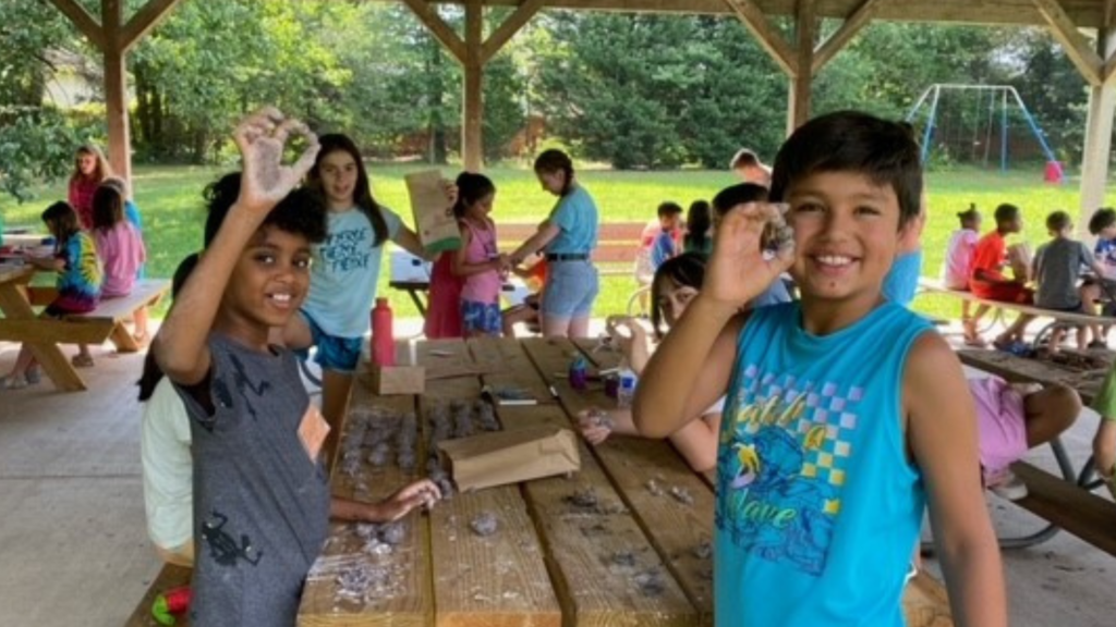 Kids showing seed bombs they made during camp.