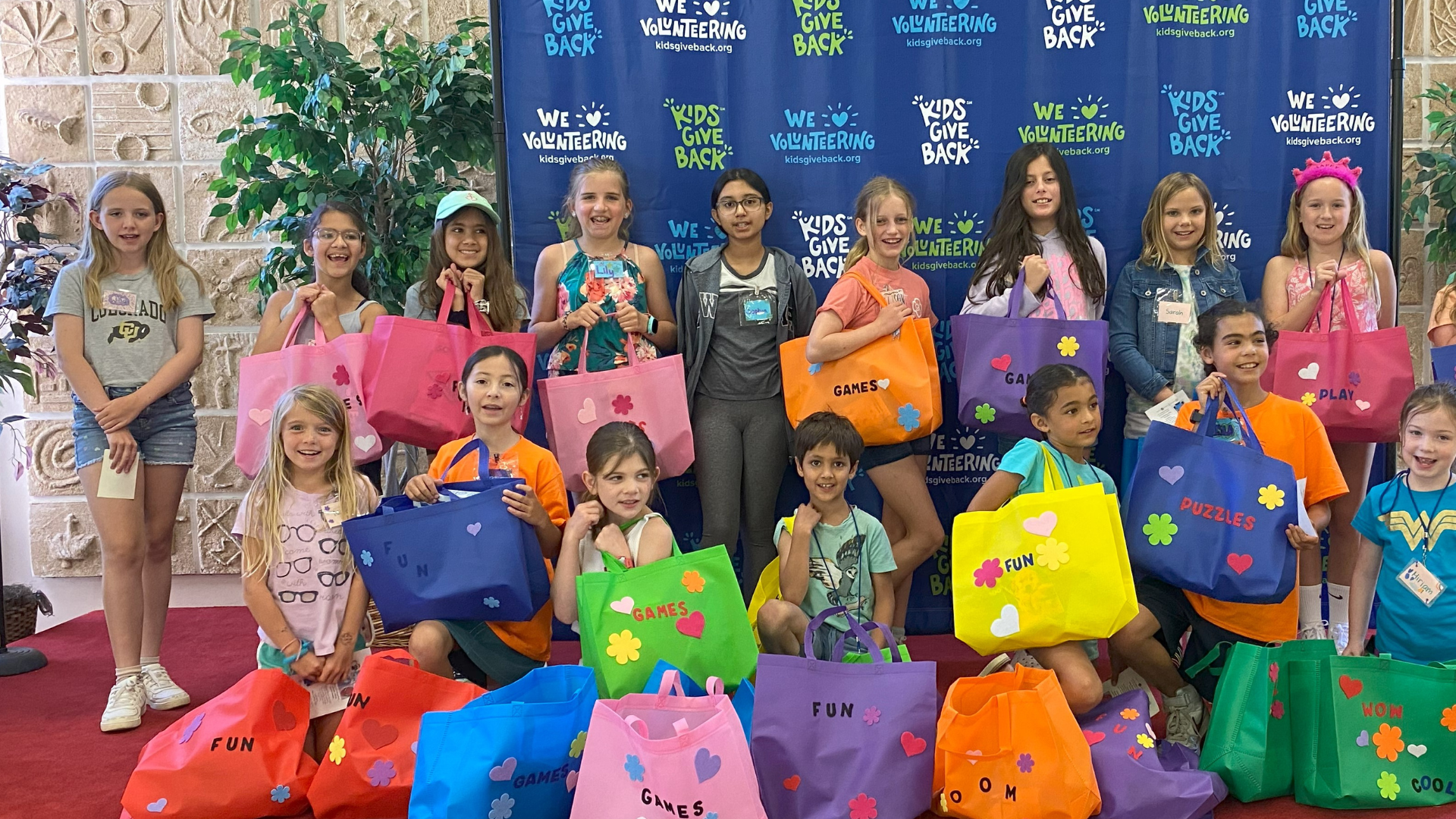 Kids pose with Family Game Night Kits for NVFS.
