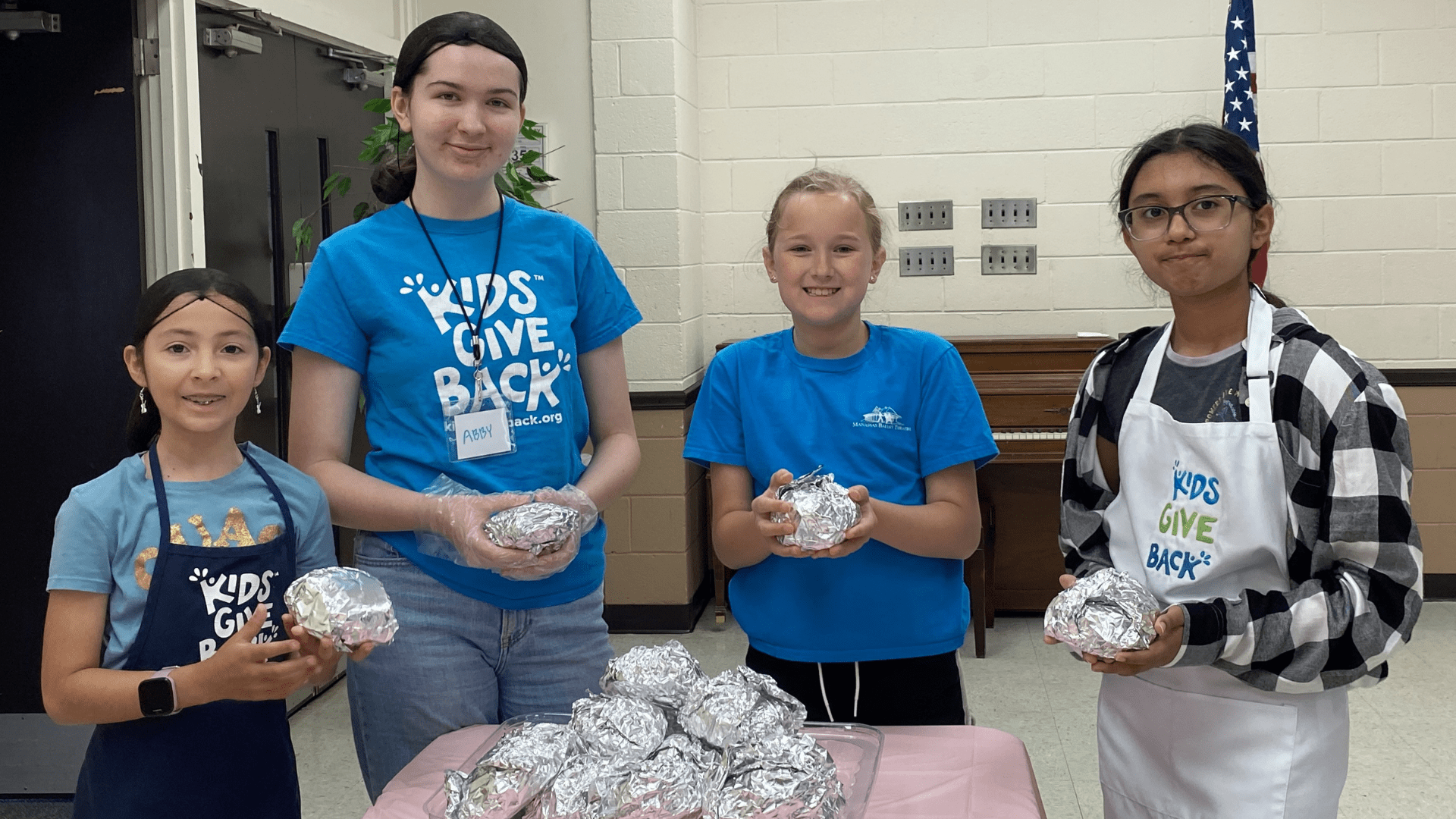 Kids with sandwiches they made for food-insecure individuals.